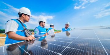 Petugas PLN melakukan inspeksi solar panel PLTS IKN.