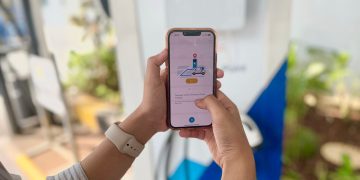 Pelanggan menggunakan fitur EV pada aplikasi PLN Mobile saat akan melakukan pengisian daya di Stasiun Pengisian Kendaraan Listrik Umum (SPKLU).