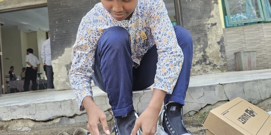 Nur Syarif Hidayatullah, siswa kelas 8 SMPN 1 Sindang Indramayu, mencoba sepatu barunya