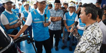 Direktur Utama PLN, Darmawan Prasodjo menyapa pengguna kendaraan listrik yang sedang melakukan pengisian daya di Stasiun Pengisian Kendaraan Listrik Umum (SPKLU) di Rest Area KM 519A Ruas Tol Solo-Ngawi, Jawa Tengah.