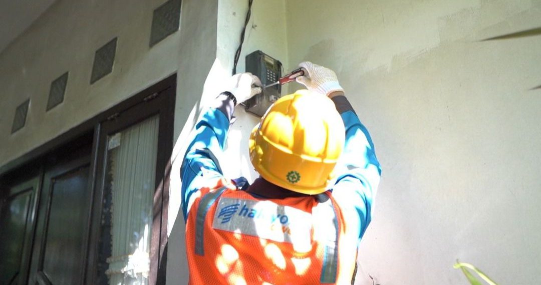 Ilustrasi Petugas PLN saat melakukan penambahan daya pada kWh meter milik pelanggan.