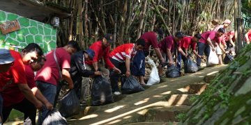 Karyawan CIMB Niaga gotong royong membersihkan bantaran Sungai Ciliwung sebagai bagian dari rangkaian Employee Volunteering Day 2025 di Depok, Sabtu (12/7/2025).