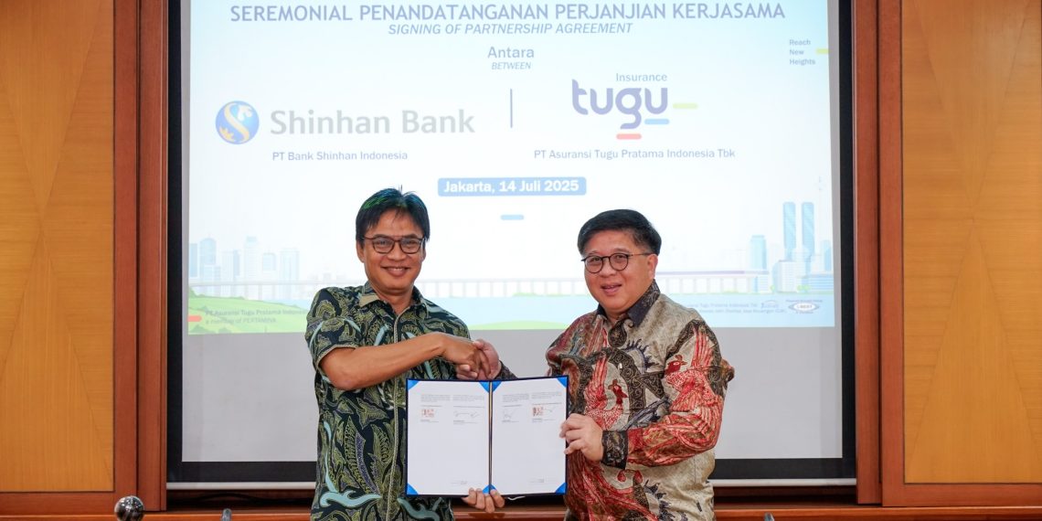 Direktur Pemasaran Tugu Insurance, Ery Widiyatmoko (kiri), berjabatan tangan dengan Direktur Kredit Bank Shinhan Indonesia, Leonard Auly