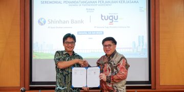 Direktur Pemasaran Tugu Insurance, Ery Widiyatmoko (kiri), berjabatan tangan dengan Direktur Kredit Bank Shinhan Indonesia, Leonard Auly