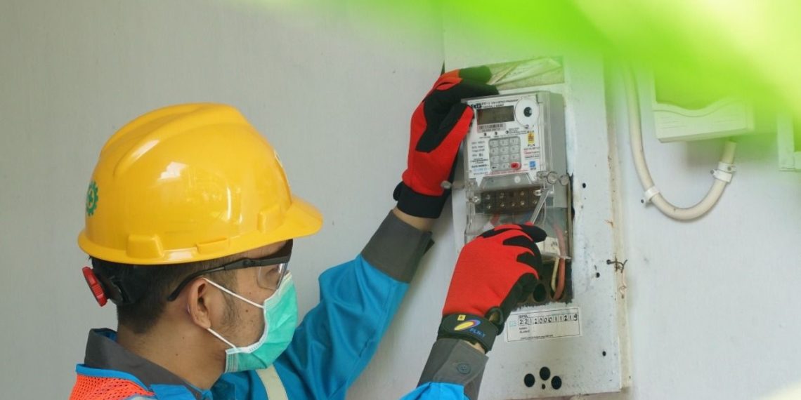 Ilustrasi petugas PLN tengah melakukan proses penambahan daya listrik di rumah pelanggan.