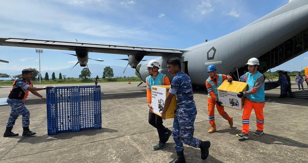 Tampak Personel PLN dan TNI Angkatan Udara bergotong royong memindahkan genset dan material tower darurat dari pesawat Hercules yang baru saja mendarat di Landasan Udara Sultan Iskandar Muda, Aceh