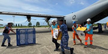 Tampak Personel PLN dan TNI Angkatan Udara bergotong royong memindahkan genset dan material tower darurat dari pesawat Hercules yang baru saja mendarat di Landasan Udara Sultan Iskandar Muda, Aceh