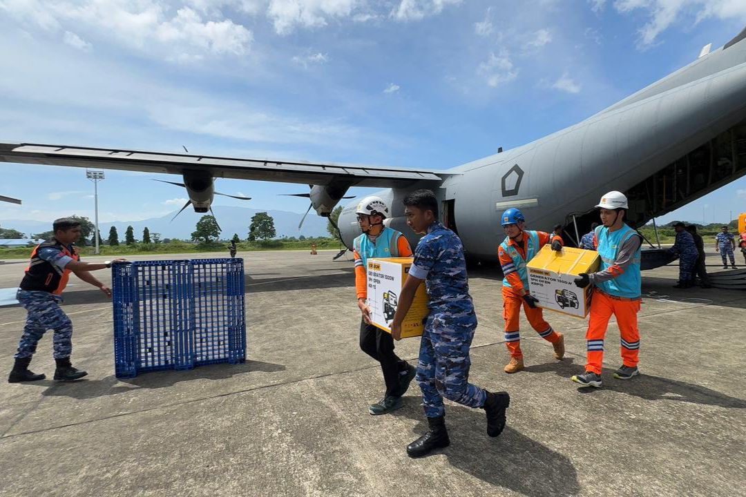 Tampak Personel PLN dan TNI Angkatan Udara bergotong royong memindahkan genset dan material tower darurat dari pesawat Hercules yang baru saja mendarat di Landasan Udara Sultan Iskandar Muda, Aceh
