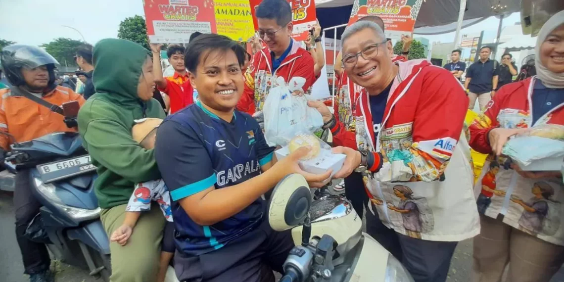 Presiden Direktur Bank Aladin Syariah Koko Rachmadi (kanan) membagikan paket makanan gratis ke masyarakat di Tangerang. (Foto: Ari Astriawan)