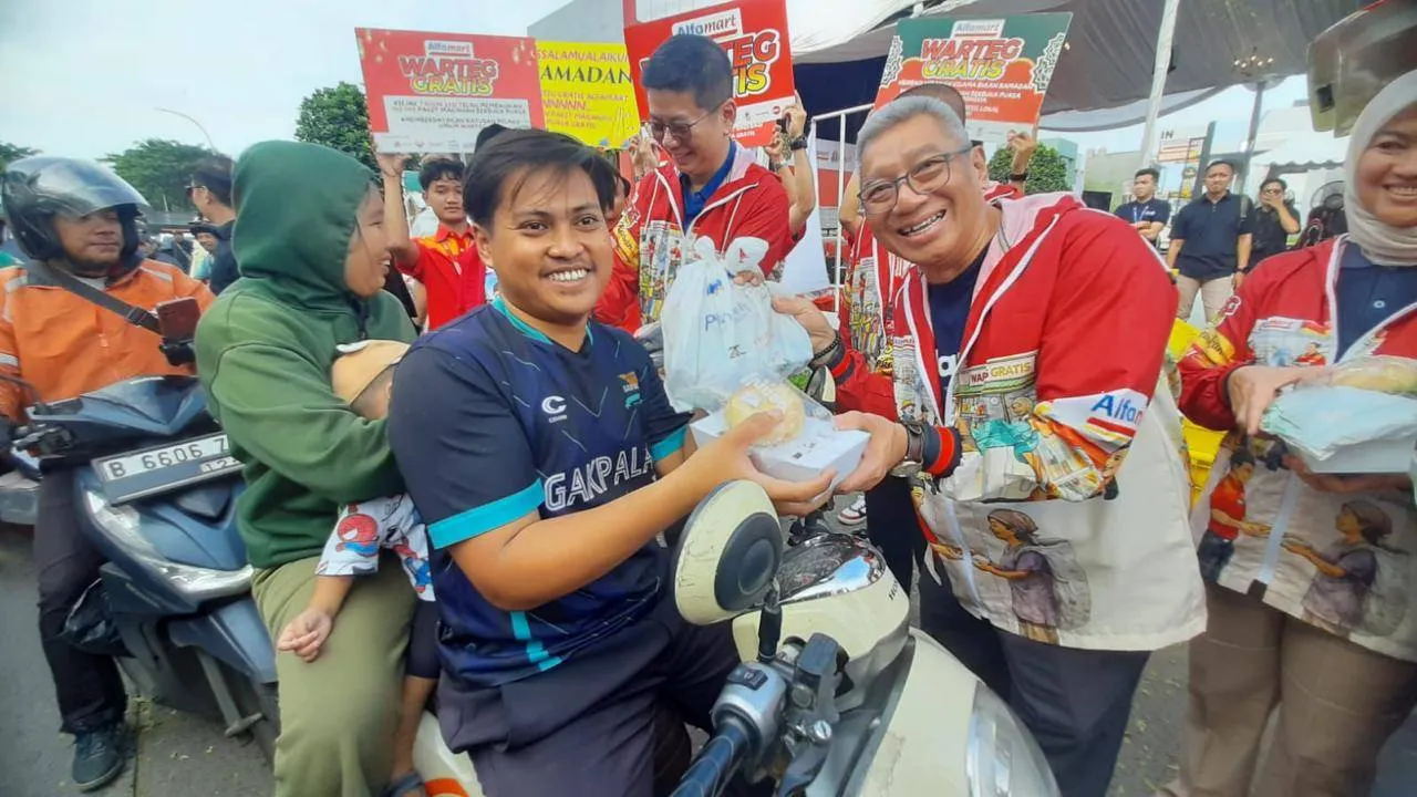 Presiden Direktur Bank Aladin Syariah Koko Rachmadi (kanan) membagikan paket makanan gratis ke masyarakat di Tangerang. (Foto: Ari Astriawan)