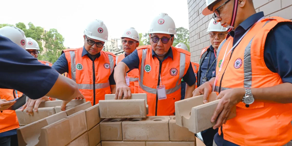 Komisaris Utama SIG, Sigit Widyawan (tengah) dan Direktur Utama SIG, Indrieffouny Indra (kanan) mengaplikasikan bata interlock presisi di Pabrik Indarung PT Semen Padang, Sumatra Barat, pada Kamis (12/2/2026).