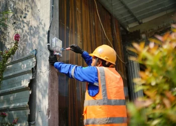 Ilustrasi petugas PLN tengah melakukan proses penambahan daya listrik di rumah pelanggan.