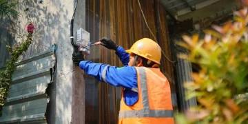 Ilustrasi petugas PLN tengah melakukan proses penambahan daya listrik di rumah pelanggan.