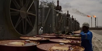 Ilustrasi pekerja mengumpulkan oli mesin saat bekerja di stasiun degassing di ladang minyak Zubair dekat Basra, Irak, pada 28 Maret 2026. (foto: AP)